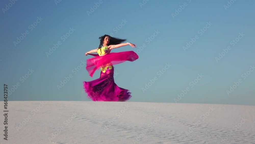 Girl with a veil in her hands dances a belly dance in the desert. Slow motion Girl with a veil in her hands dances a belly dance in the desert. Slow motion