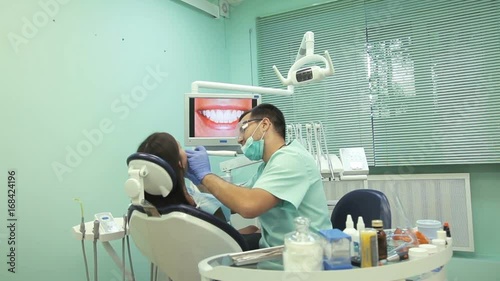 Doctor shows on the monitor the healthy teeth of the patient photo