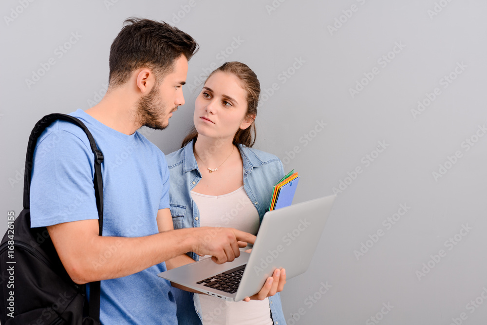 portrait of two student male and female on grey plain background with copyspace portrait of two student male and female on grey plain background with copyspace