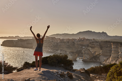 Foto Ragazza felice salta sulla spiaggia al tramonto