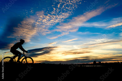 Silhouette of cyclist in motion on the background of beautiful sunset ride bicycle on sunset background Silhouette of man ride a bike in sunset background.