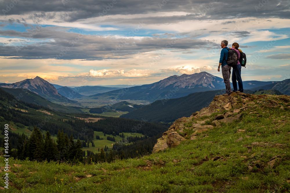 Hikers looking down on Crested Butte at sunset