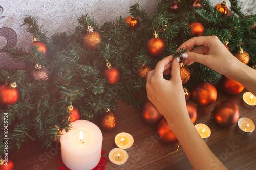 Cute young woman decorating room and preparing for Christmas holiday
