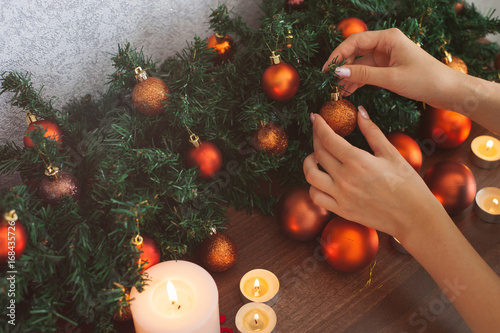 Cute young woman decorating room and preparing for Christmas holiday
