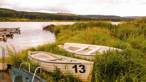 Fotografie Unlucky number thirteen rowing boat full of water beside reservoir