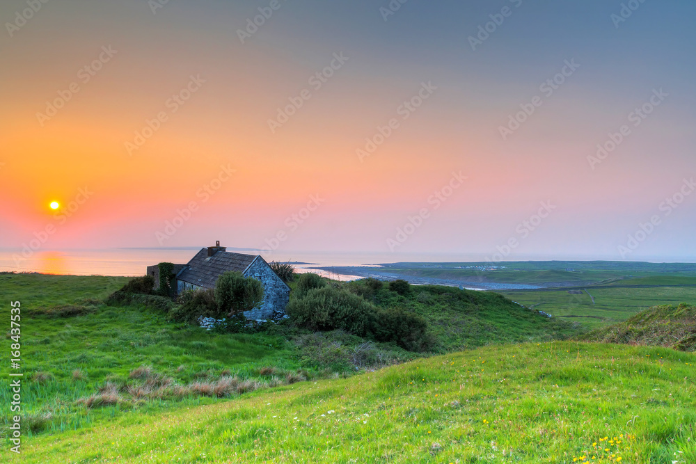 Fototapeta premium Irish cottage house at sunset