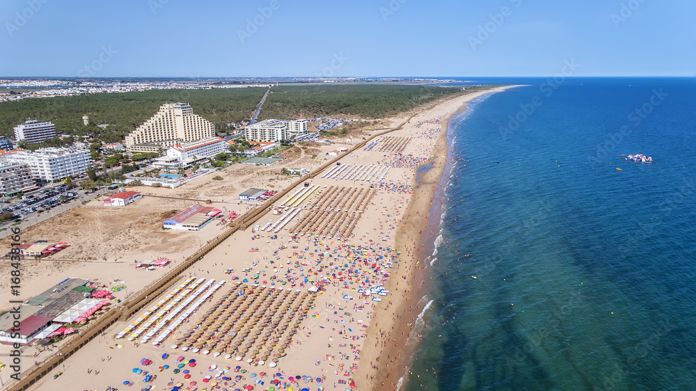 Aerial. Numerous tourists on the Monte Gordo beach. View from sky.