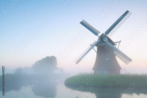 charming windmill in morning fog