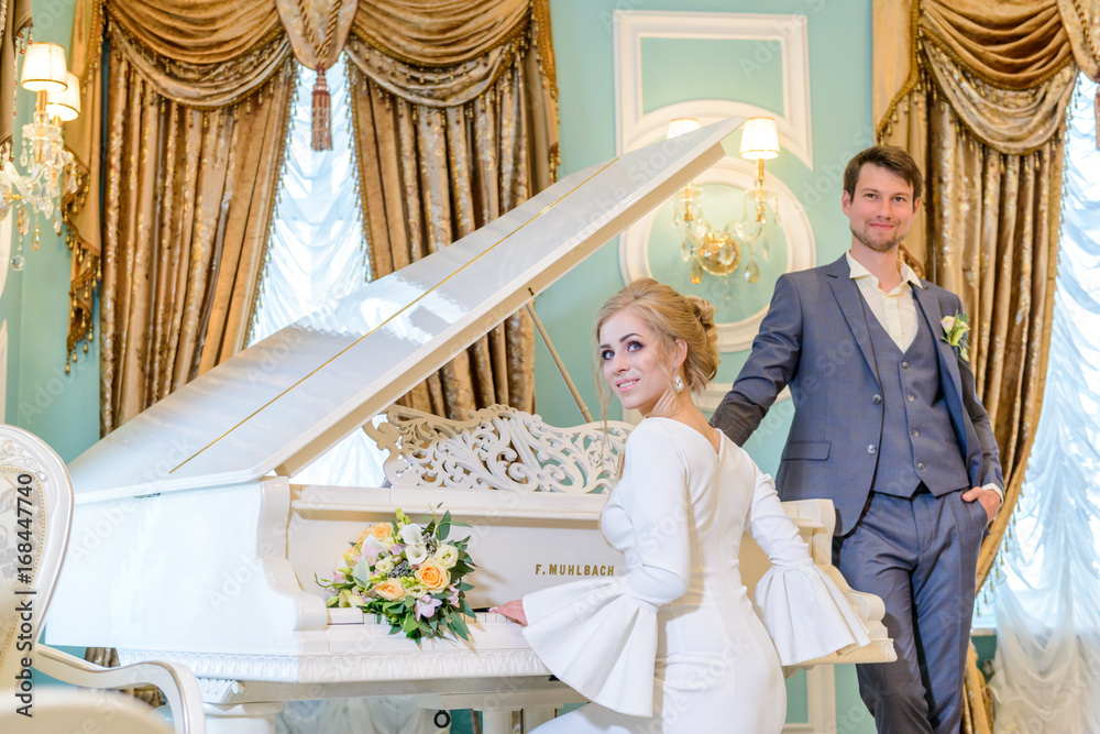 bride and groom near the white piano