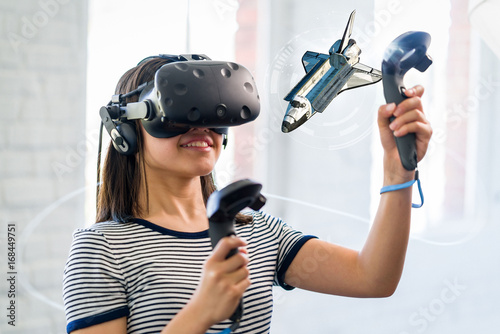 A teenage student wearing a virtual reality headset to study science.