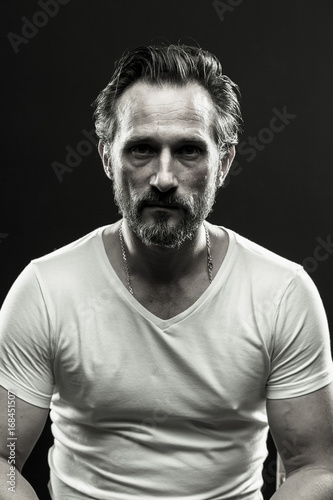 Black and white portrait of brutal beardy man. Monochrome photo of mid aged male on black backdrop. © Svyatoslav Lypynskyy