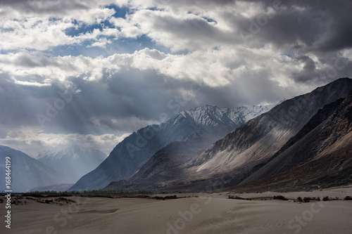 Light beam casting to mountain in Hunder sand dunes, Nubra valley, Ladakh