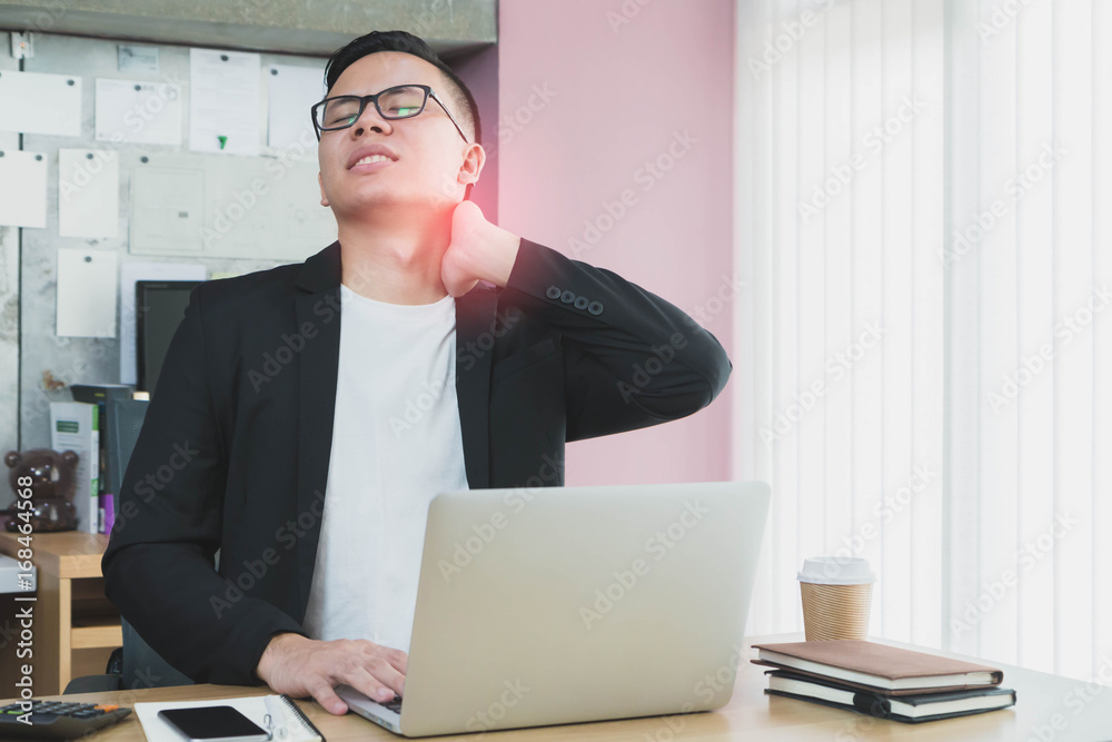 Asian businessman feeling neck pain because sit and working for a long time in the office.Concept of Healthcare and Office syndrome. Asian businessman feeling neck pain because sit and working for a long time in the office.Concept of Healthcare and Office syndrome.