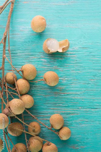 Longan Fresh (Dimocarpus longan.)A bunch of Longan and Peel show the white meat with black seed was placed on a wooden background. L