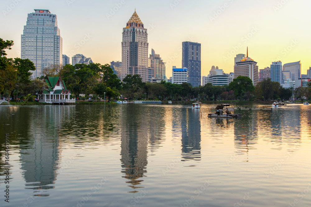 Business district cityscape from a park with sunset time from Lumpini Park, Bangkok, Thailand