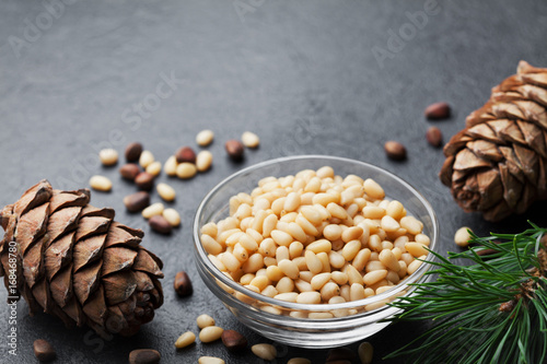 Foto Pine nuts and cedar cones on black table