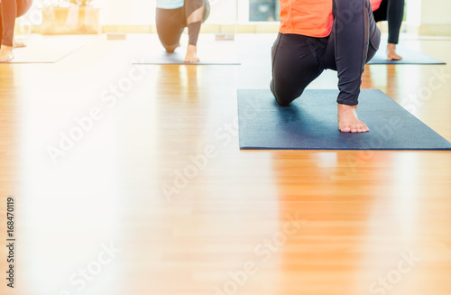 Close up feet of yoga class stretching on mat at studio classroom,healthy lifestyle sport.