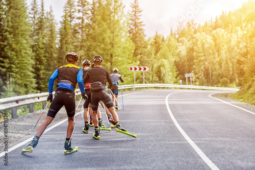 Canvastavla Team biotlonists in sports equipment, protective helmets hold in the hands ski p