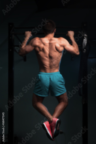 Muscular fitness model doing pull up exercise