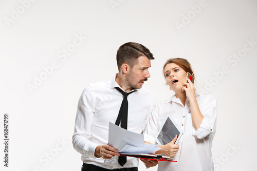 The business man and woman communicating on a gray background