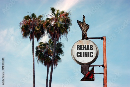 aged and worn vintage photo of rehab clinic sign with palm trees