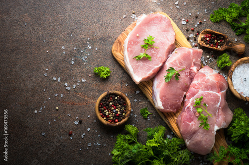 Fresh meat. Raw pork steak. Top view on stone table. Food background.