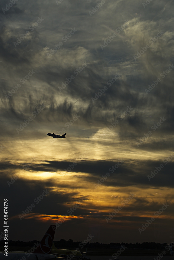 Aeroplane (airplane) taking off (Dusseldorf Airport) at sunset, Germany. Aeroplane (airplane) taking off (Dusseldorf Airport) at sunset, Germany.