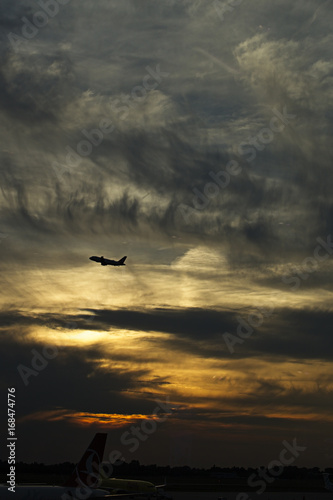 Aeroplane (airplane) taking off (Dusseldorf Airport) at sunset, Germany.