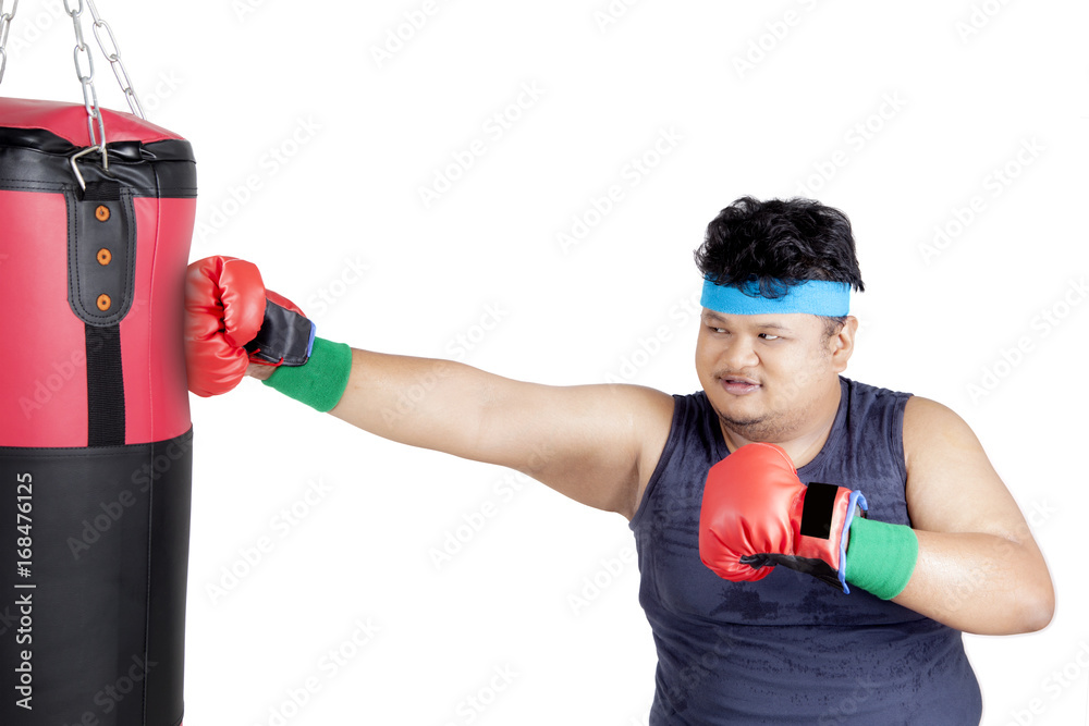 Overweight man punching boxing sack