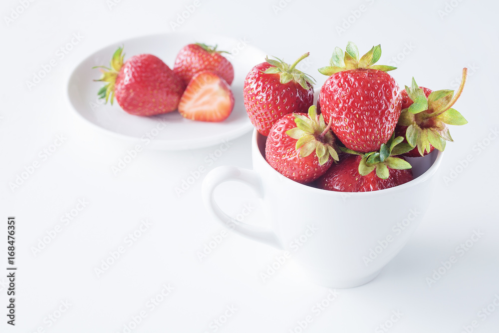 Fresh strawberries in white white cup on white background. Copy space. Fresh strawberries in white white cup on white background. Copy space.