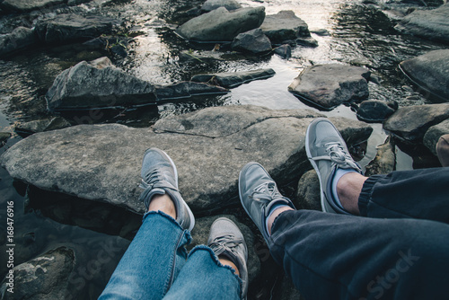 Canvas Print couple sits near mountain river and looking on sunset