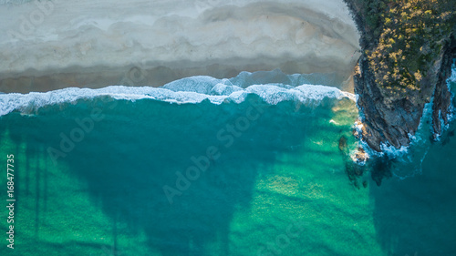 Empty beach with rocky headland from above photo