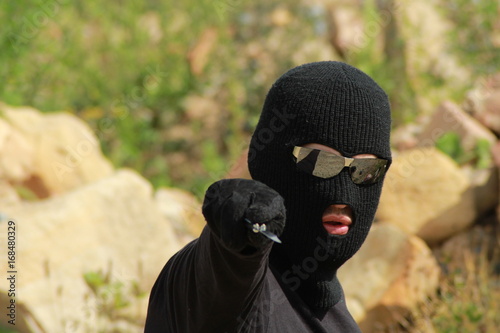 Bilde på lerret Man aggressor with balaclava hold knife/ Man aggressor in black clothes with balaclava hold knife