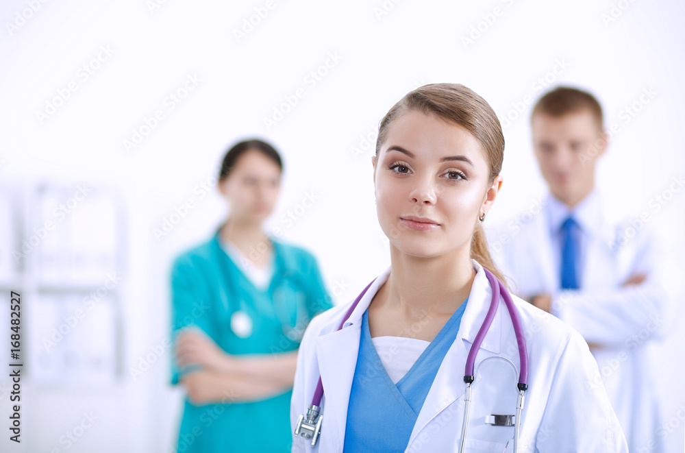 Attractive female doctor in front of medical group Attractive female doctor in front of medical group