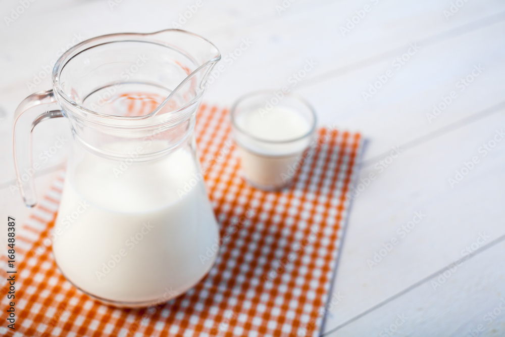 jug of milk and glasses of milk on a wooden rustic table. jug of milk and glasses of milk on a wooden rustic table.