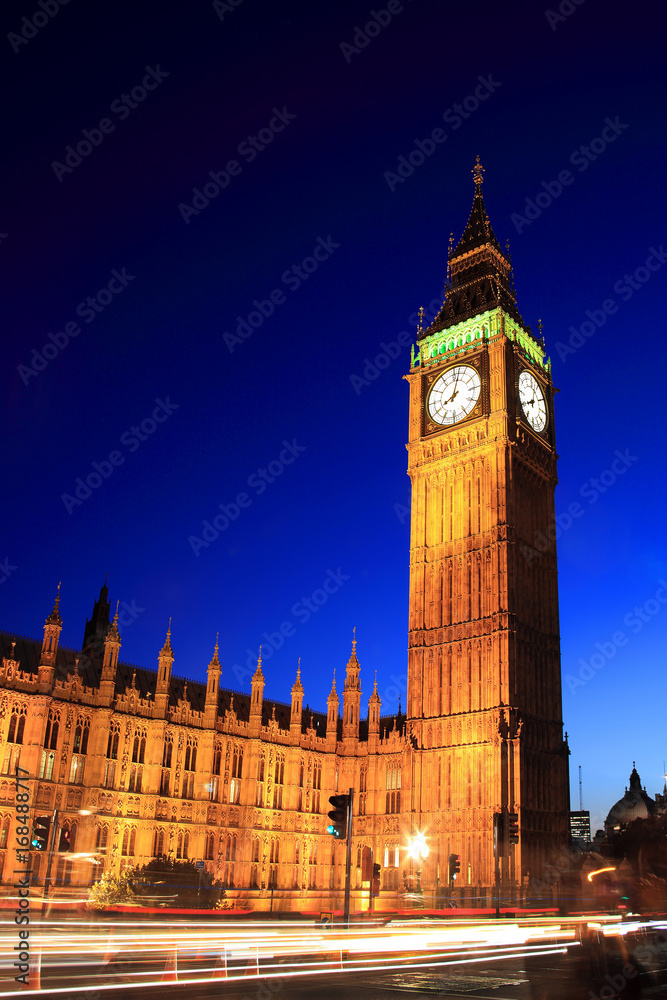 Big Ben of the Houses of Parliament at night with car light trails