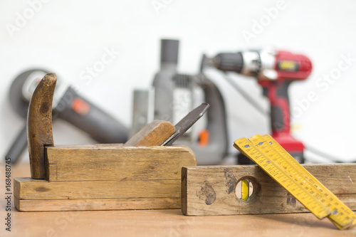 Old carpenter joinery in the foreground. Angle grinder, fretsaw and screwdriver in the background.