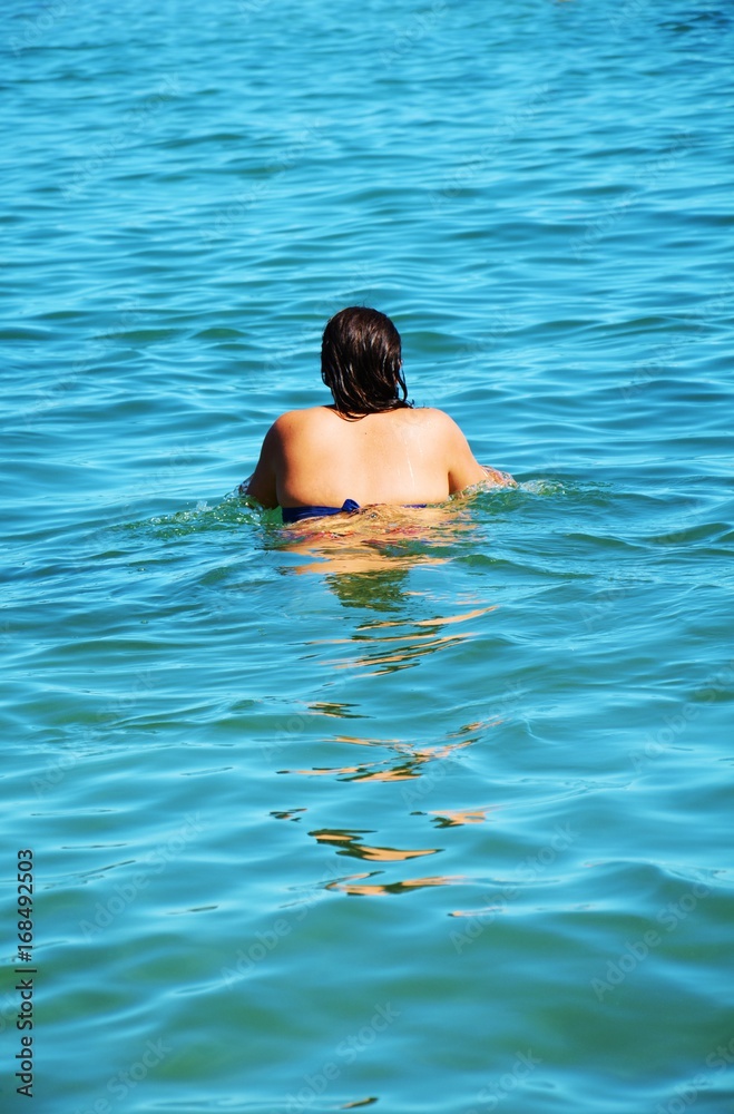 Woman swimming in Tyrrhenian sea, Elba island