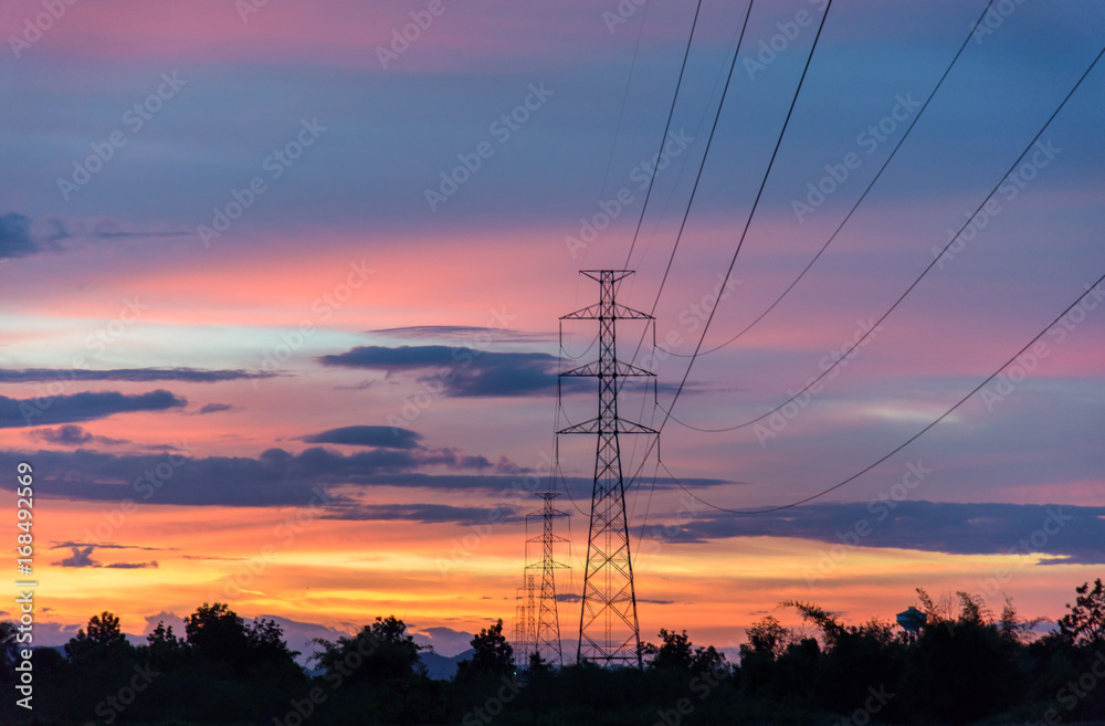 Silhouette of high voltage towers on the field and twilight. An image of high voltage towers and the sunset background.