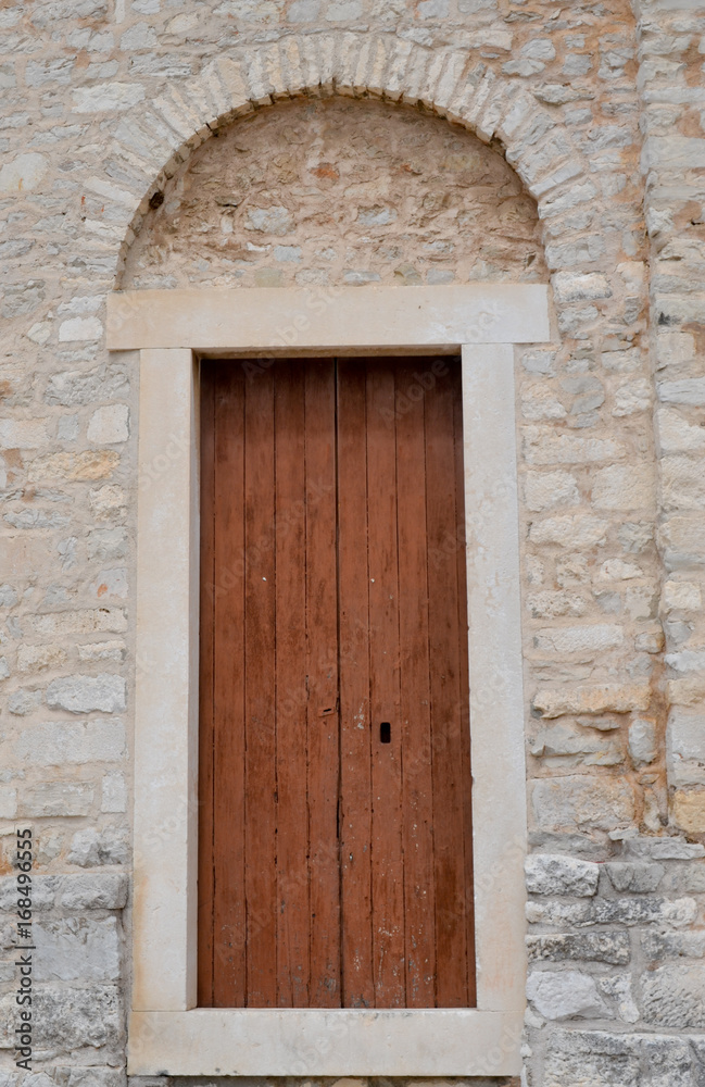 Brown old door located in old limestone building