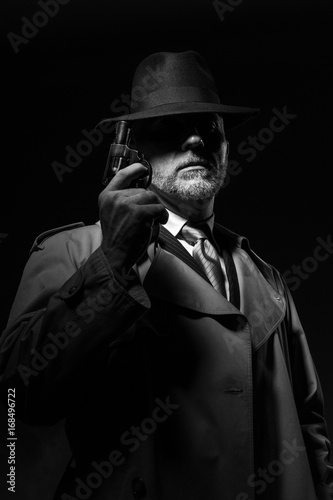 Detective holding a gun in the dark