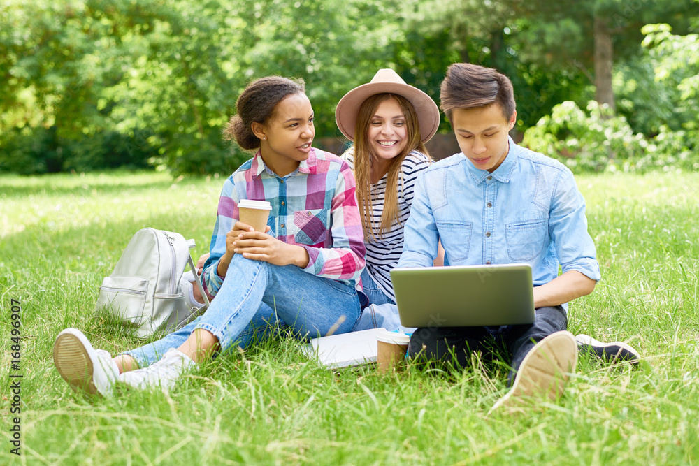 Group of Happy Students Enjoying Break on Lawn Group of Happy Students Enjoying Break on Lawn
