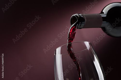 Pouring red wine into a wineglass photo