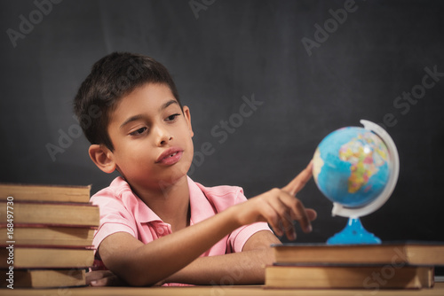 Boy looking globe of earth photo