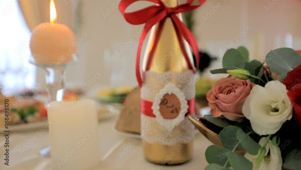 Champagne with the initials of the newlyweds is on the wedding table. Interior of a wedding concept. Blurred background Champagne with the initials of the newlyweds is on the wedding table. Interior of a wedding concept. Blurred background