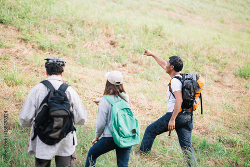Group of backpacking hikers going to mountain top. Backpackers or Hikers travel concept. Selective focus.
