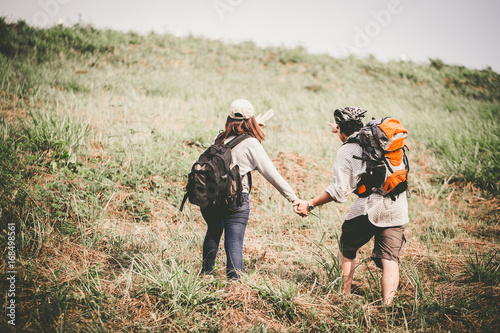 Couple of backpacking hikers going to mountain top and navigating by map paper. Backpackers or Hikers travel concept. Selective focus and vintage tone. © chayantorn