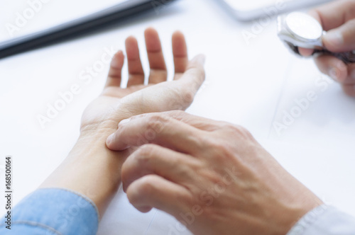 crop image of doctor take the pulse of patient