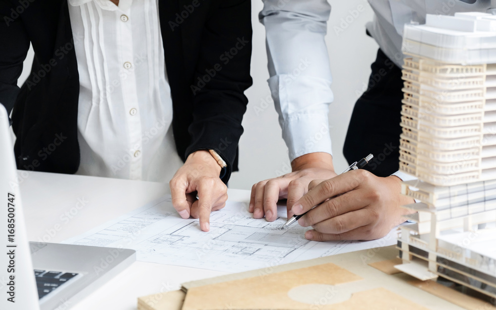 Hands of Engineers working on blueprint at a workplace, Construction and building concept
