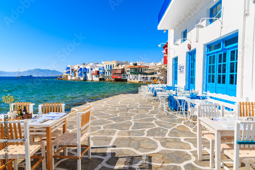MYKONOS ISLAND, GREECE - MAY 16, 2016: Typical Greek tavern in Little Venice, a part of Mykonos town on island of Mykonos, Greece.